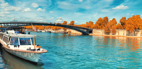 Paris, panoramic image of passenger ship on Seine river in Autumn