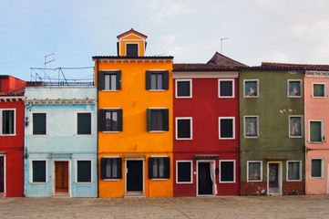 street of colourful houses in burano venice in summer with blue sky