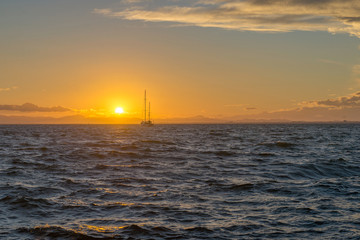 Fototapeta na wymiar Sailing yacht and sunset in the sea. La Manga. Spain.