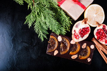 Chocolate, lemon, pomegranate and cinnamon on black backdround
