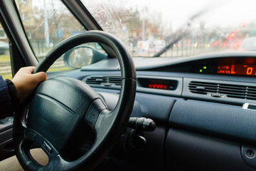Man hand on steering wheel driving car.