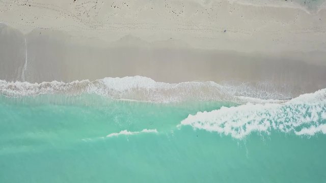 aerial view of greenish-blue wavy ocean near clean sandy coastline on day time,sunny isles beach,miami