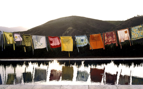 Colorful aprons drying on clothes line over pool