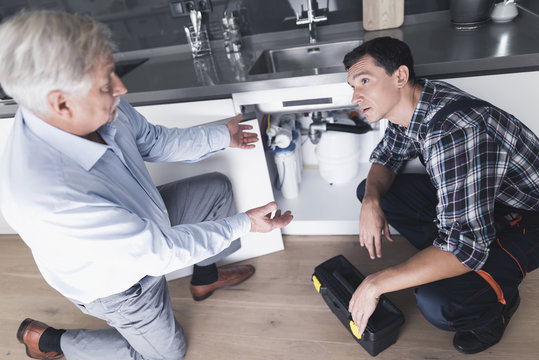 A man plumber speaks with a client who is dissatisfied with the work done.