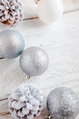 Fototapeta na wymiar White Christmas background from above. Frosty pine cones, white, glitter, silver colored decoration balls. Minimalist style. Copyspace for text, overhead, horizontal