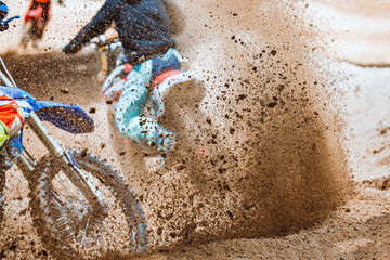 Details of flying debris during an acceleration with mountain bikes race in dirt track in sunshine...