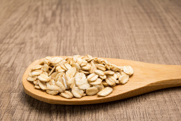 Oat cereal grain. Grains in wooden spoon. Rustic.