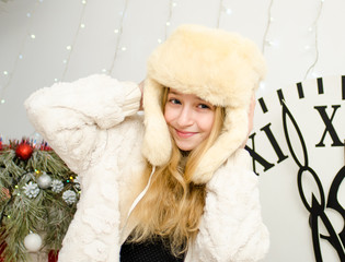 New Year, Beautiful young blond woman in a hat hat with ears on a clock background