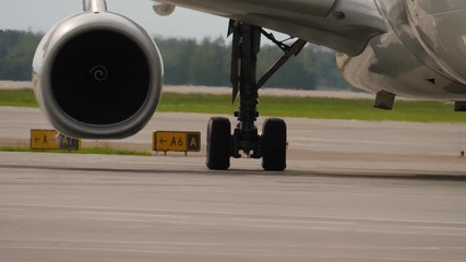 Jet engine and landing gear of taxiing aircraft. Heat haze behind plane engine