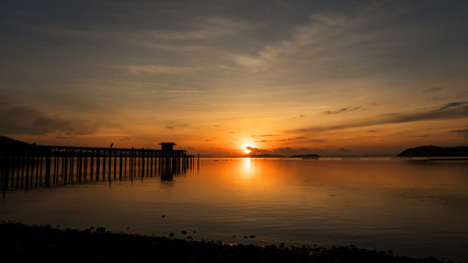 Obraz premium scenery view of old jetty to the sea beautiful sunrise or sunset in phuket thailand.