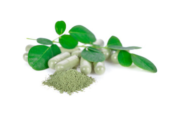 fresh moringa leaves, ground and capsule herbal on white background