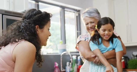 Mother, daughter and granny having fun in the kitchen  