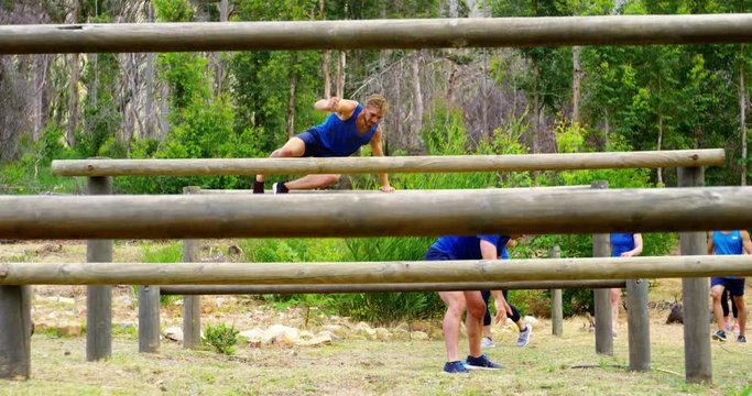 Fit people jumping over the hurdles during obstacle course 