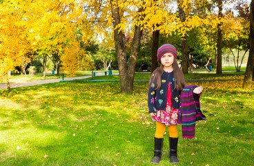 Autumn portrait of beautiful kazakh, asian child. Happy little girl with leaves in the park in fall.