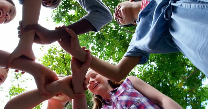 Schoolkids holding each other hands in school premises 