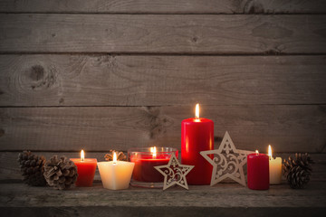 Christmas decoration with red candles on wooden background