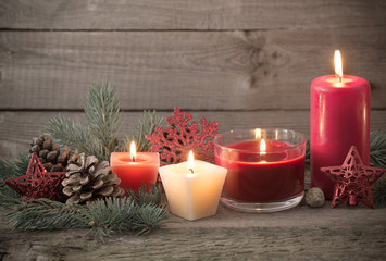 Christmas decoration with red candles on wooden background