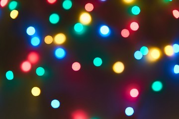 Blurred bright bokeh lights on black background, against blurred bright background,Christmas and New Year Holiday firework.Bright abstract background ideal for any design
