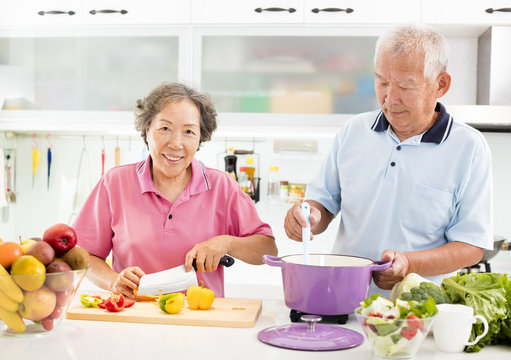 Happy Senior Couple Cooking In Kitchen