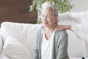 Grandmother is massaged by her grandchild