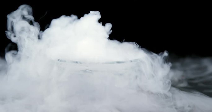 Ice smoke in bowl against black background 