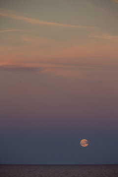 Romantischer Sonnenuntergang, Mond brennt am bunten Himmel