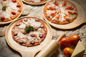 Fresh delicious Italian pizza with mushrooms on thin crust, on a wooden serving plate