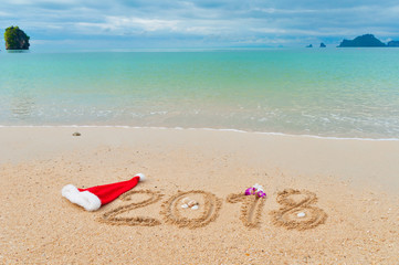 New year 2018 holiday vacation concept, 2018 written on tropical beach sand background
