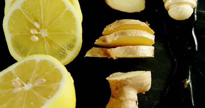Lime, ginger and honey dipper in black background 