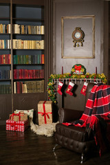 The beautiful interior is decorated for Christmas. Hall, living room, office with a large leather chair, a bookcase with a fireplace. New Year's room with a wreath, a garland, gifts. Place for your te