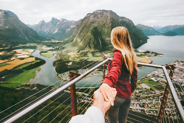 Couple Man and Woman follow holding hands in Norway mountains Love and Travel happy emotions Lifestyle concept. Young family traveling active adventure vacations Rampestreken aerial view