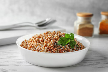 Bowl with cooked buckwheat on table