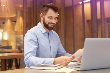 Handsome marketing manager working in cafe