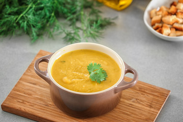 Board with tureen of homemade lentils creme soup on table