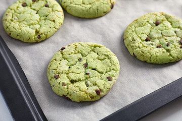 Fresh mint chocolate chip cookies on baking tray, closeup
