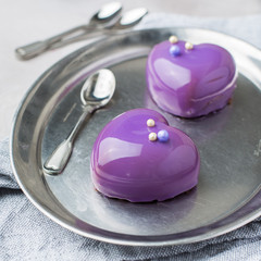 Mousse cakes "Hearts" on a metal vintage tray. Gray concrete background. A modern dessert