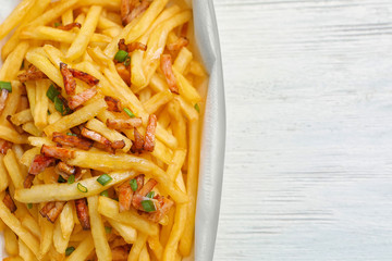 Box with french fries and bacon on table