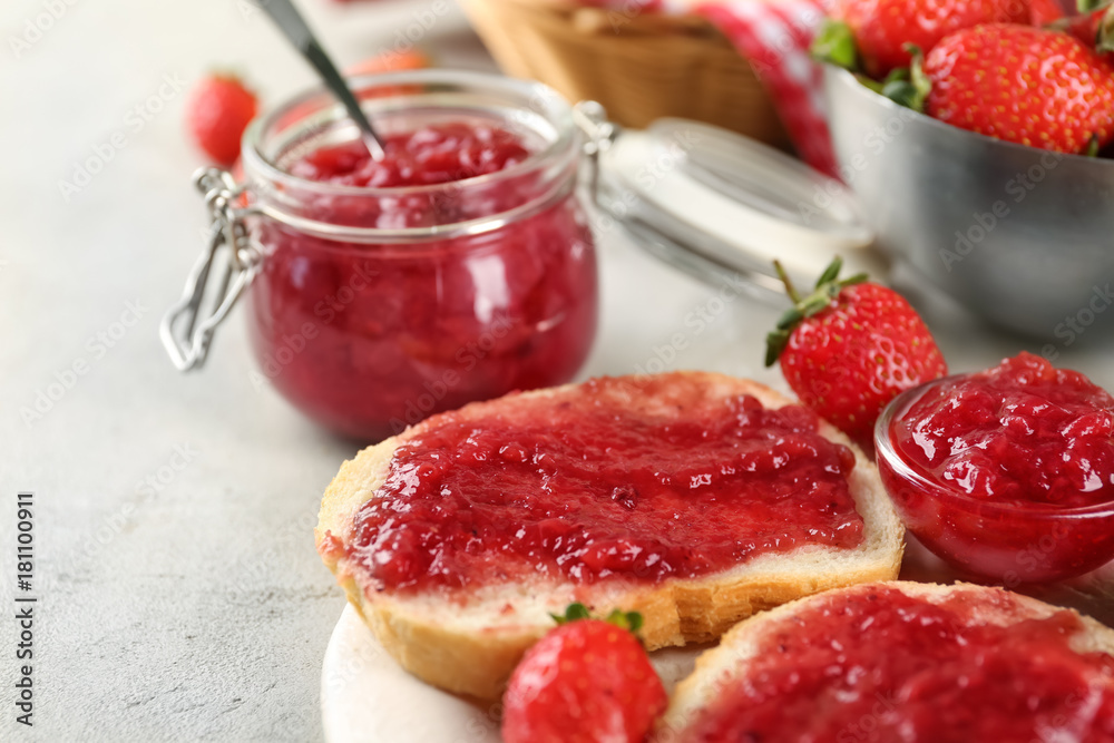 Wall mural plate with pieces of bread and strawberry jam on table