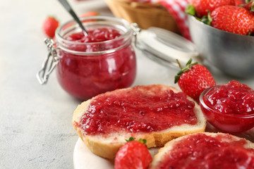 Plate with pieces of bread and strawberry jam on table