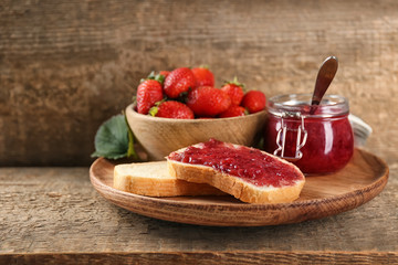 Composition with bread, homemade jam and fresh strawberries on table