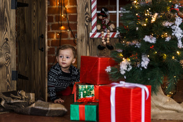 Fototapeta na wymiar Little boy in christmas decorations. Dressed in ornamental sweater