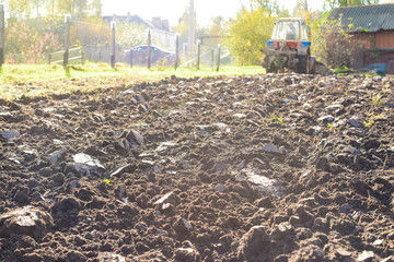 Tractor plowing a land, rural life in Russia. Concept of agriculture, farming, poverty and decline