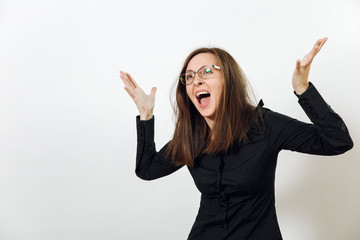 Pretty European young angry brown-haired woman in glasses for sight with healthy clean skin, dressed in a dark black shirt, screaming and swearing, on a white background. Emotions concept.