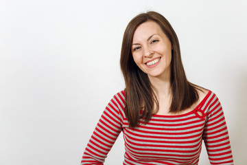 Gorgeous European young happy brown-haired woman with healthy clean skin and charming smile, dressed in casual red and grey clothes, laughing and enjoying on a white background. Emotions concept.