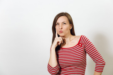 Fototapeta premium Pretty European young worried and pensive brown-haired woman with healthy clean skin, dressed in casual red and grey clothes lost in thought and conjectures, on a white background. Emotions concept.