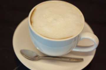 Hot coffee in a white cup in a coffee shop