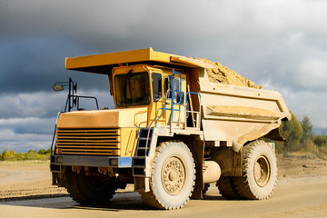 Extraction of minerals. Big yellow mining truck transporting materials