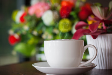 Fototapeta na wymiar Hot coffee in a white cup in a coffee shop