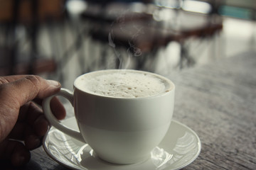 Hot coffee in a white cup in a coffee shop
