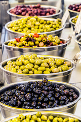 Different cured table olives in the bowls.